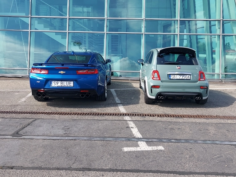 dwa auta stojące na parkingu w jasny dzień